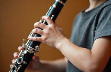 Fototapeta premium Childrens hands play clarinet in music studio. Young person practices woodwind instrument, learns musical notes and melody. Child develops finger technique for band class.