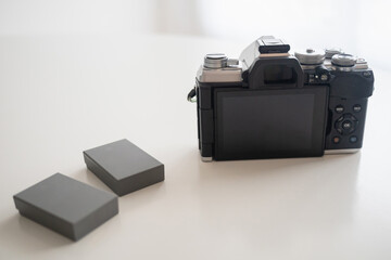 Modern digital camera with a vintage look (viewed from the back) and 2 extra batteries