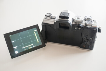Modern digital camera with a vintage look, seen from the back with the tilting screen unfolded
