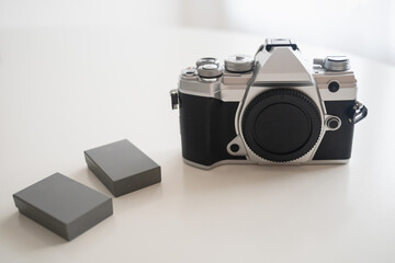 Modern digital camera with a vintage look (front view) and 2 extra batteries