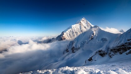Obraz premium A Majestic Snowy Mountain Peak Rising Above Fluffy Clouds Showcasing Natural Beauty And Serenity In A Breathtaking Alpine Landscape