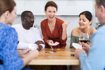 Friends who enjoy lively game of poker and pleasure of tasting fine wine in the comfort of their own home