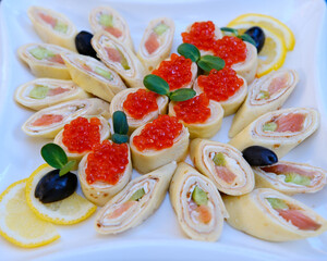 Rolls of thin pancakes with smoked salmon, horseradish cream cheese and rocket leaves . High quality photo