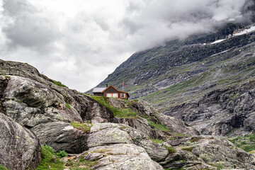 Alnestinden Mountain rises dramatically above cozy cabin in the Trollstigen Landskapsvernområde Landscape Protection Area, showcasing Norway's stunning natural beauty