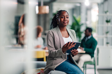 Confident black businesswoman using digital tablet in office