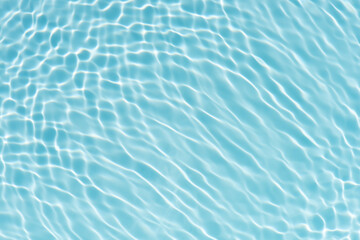 Blue water with ripples on the surface. Defocus blurred transparent blue colored clear calm water surface texture with splashes and bubbles. Water waves with shining pattern texture background.