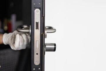 Closeup  handyman repairing home entrance access door lock at the office.