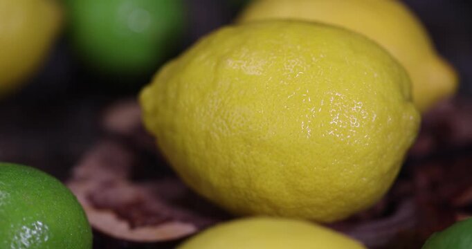yellow sweet and sour lemon and limes lying on the table, ripe citrus fruits lemons and limes lying on a wooden table