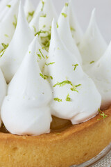 Lemon meringue tart with fresh lime zest on crust