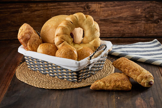 Basket filled with fresh baked goods on wood table - Powered by Adobe