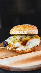 Succulent chicken breast burger on brioche bun with cheese, pickles, homemade mayo and barbecue sauce. Healthy, protein-rich meal perfect for fitness and balanced diets.