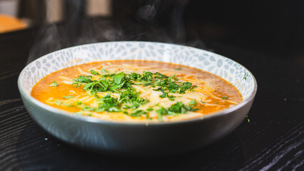 Thick vegetable soup with tender meat, melted cheese, and fresh parsley on top. Hearty, comforting, and perfect for cold days. Homemade and nutritious.