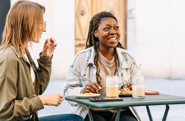 Diverse women friends enjoying outdoor cafe brunch and conversation