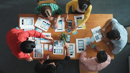 Creative team sitting and discussing while brainstorm about Ux Ui design mobile phone interface. People planning strategy start up project while planning a strategy at business meeting. Convocation.