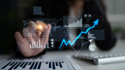 A businesswoman using technology to analyze data trends in a modern office, showcasing virtual graphs that illustrate growth metrics and strategic insights. Scalp