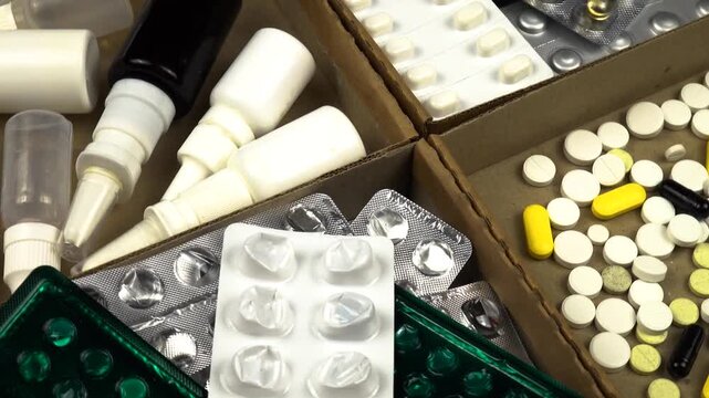 Expired medications, blisters, and used medication vials in boxes, preparing for disposal. Treatment and medicines concept