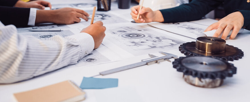 A vibrant scene of engineers working together to create mechanical designs. They analyze sketches, discuss ideas, and utilize drafting tools to innovate solutions. SACTR