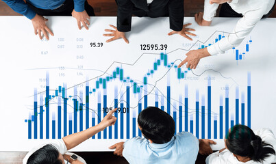 A group of professionals collaborating over financial data, analyzing charts and graphs to derive...