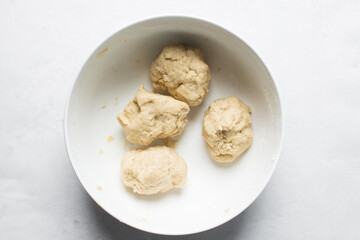 Overhead view of nigerian egg roll dough in a white bowl, overhead view of dough for making egg roll, process of making egg rolls