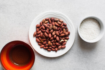 overhead view of mise en place of ingredients for making coated peanuts, process of making nigerian coated peanuts or cracker nut
