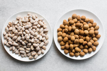Overhead view of coated peanuts and cracker peanuts on a marble countertop, top view of nigerian peanut snack