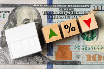 Real estate market fluctuations with wooden blocks with up and down arrows and a percent sign symbolize changing mortgage interest rates and housing prices.
