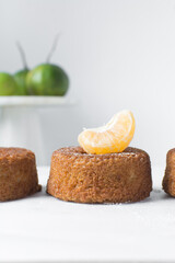 close up view of mini citrus cakes on a white countertop, mini citrus bundt cakes on a white background