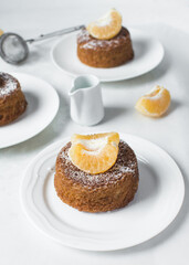 close up view of mini citrus bundtlette cakes on a white countertop, mini citrus bundt cakes on a white background