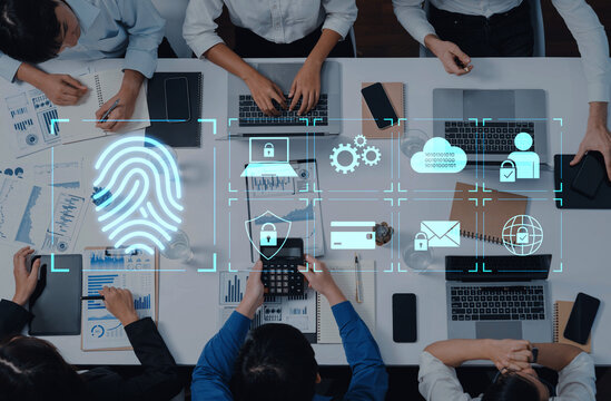 A modern business meeting showcasing teamwork and technology, featuring laptops, smartphones, and digital security icons for effective data management and protection. Trope