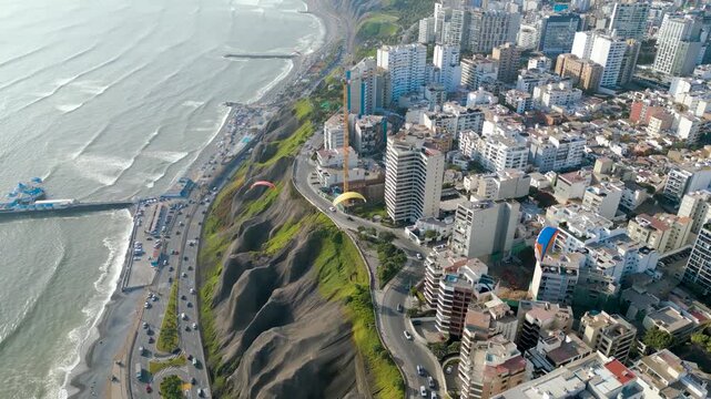 Beautiful aerial view of the Costa Verde in Miraflores, Peru with paragliders on a summer afternoon.