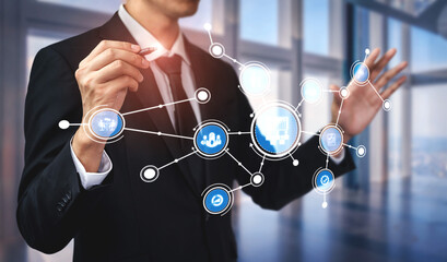 A businessman engages with a digital interface, showcasing data connections and visualizations in a sleek office, symbolizing modern business solutions and analytics. Tessel