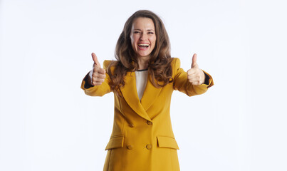 A smiling businesswoman in mustard yellow blazer gives double thumbs-up gesture, radiating...