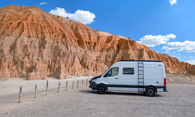 Camper van parked at dramatic red rock cliffs in Cathedral Gorge State Park