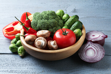 Different fresh raw vegetables on grey wooden table, closeup