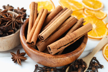 Mulled wine spices. Cinnamon sticks, anise stars, cloves and dry orange slices on light table, closeup