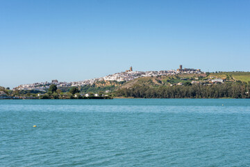 Fototapeta premium Arcos de la Frontera white village overlooking reservoir lake in Andalusia, Spain