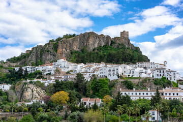 Zahara de la Sierra village built on a hillside with a historic castle above in Pueblos Blancos of Andalusia, in Spain