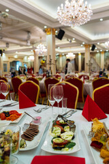 Vilnius, Lithuania - May 9 2025 - A formal banquet hall is set with tables adorned with red napkins and elegant place settings, awaiting guests for a celebratory meal.