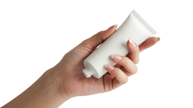Woman's hand holding a white cosmetic cream tube with manicured nails isolated on a transparent background