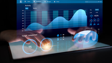 A person uses a tablet to interact with a digital dashboard displaying activity metrics and graphs. Ideal for showcasing technology and performance analytics. Impute