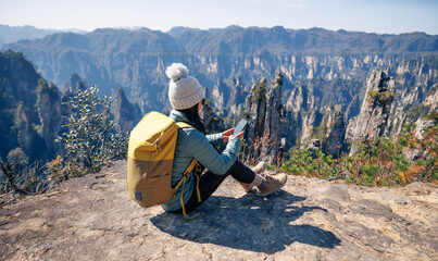 Female  tourist taking selfie with smart phone hiking in mountains © lzf