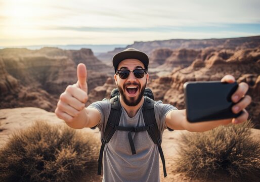 Cheerful young man taking a wide angle selfie, giving a thumbs up