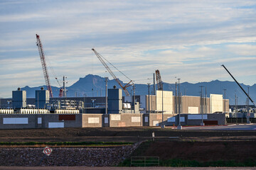 Large data center campus with completed buildings and active construction zones, featuring cranes, structural modules, and utility infrastructure supporting high-capacity digital operations