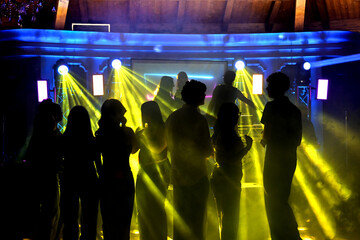ragazzi ballano in una discoteca illuminati dai faretti