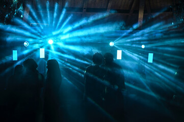 ragazzi ballano in una discoteca illuminati dai faretti