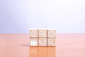 Wooden blocks with business strategy icons showing growth, innovation, teamwork, and target achievement concept. Ideal for marketing, planning, and business development presentations.