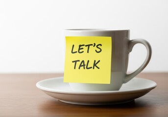 Coffee mug with 'let's talk' sticky note, open dialogue message
