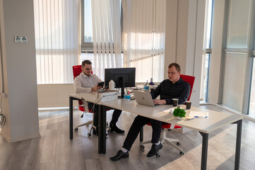 Two Caucasian men working in an office. 