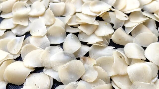 Raw cracker slices drying on a tray, indonesian traditional snack food background