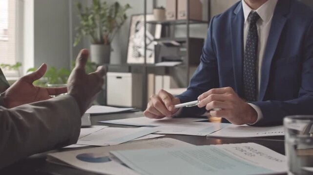 Two Male Colleagues Shaking Hands During Morning Office Meeting